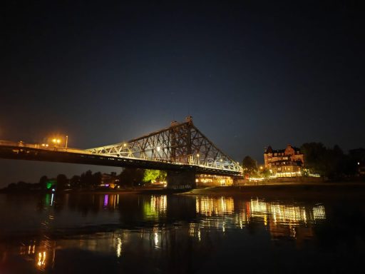 Beleuchtete Elbbrücke in Dresden während einer nächtlichen Bootsfahrt